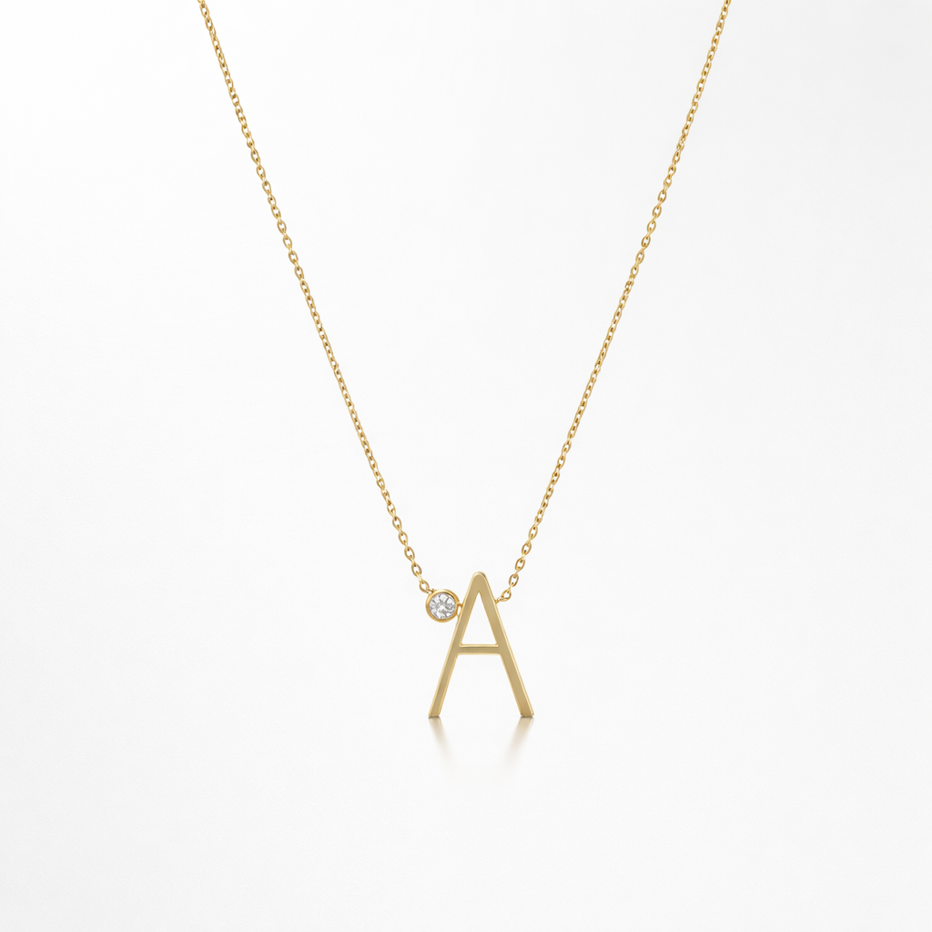 Gold necklace with 'A' pendant on a white background