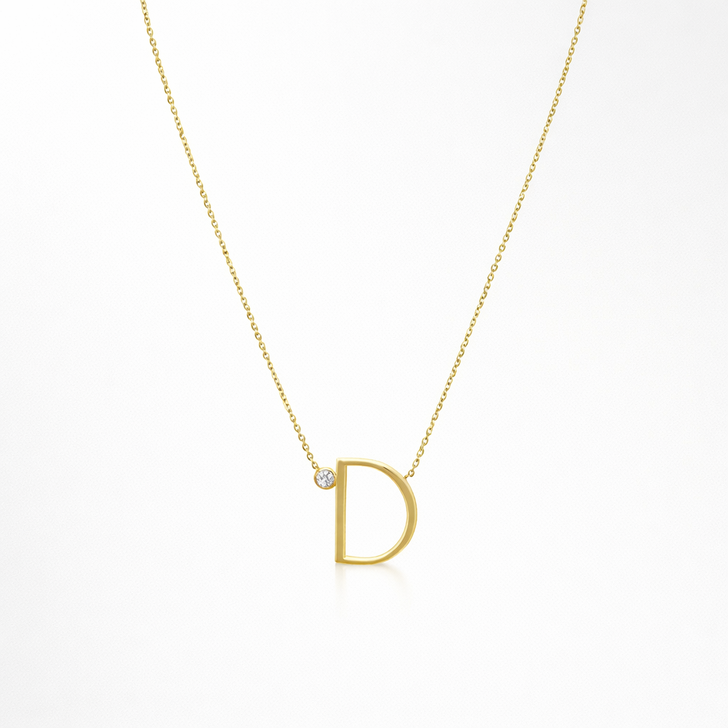 Gold necklace with a 'D' pendant on a white background