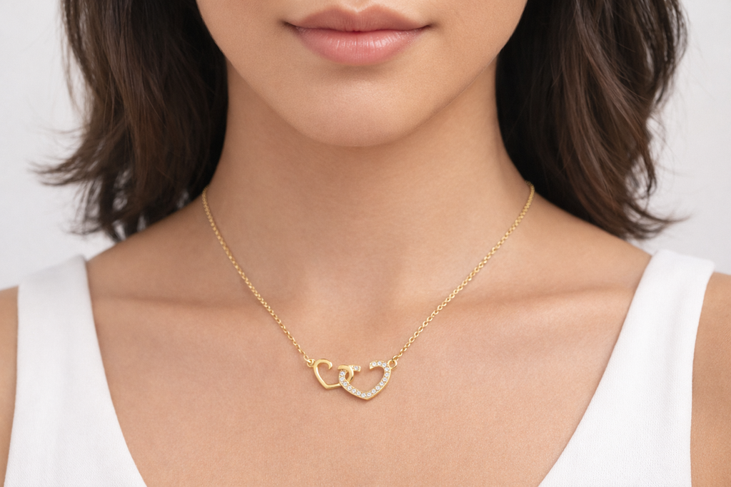 Gold necklace with interlocking heart pendants worn by a person
