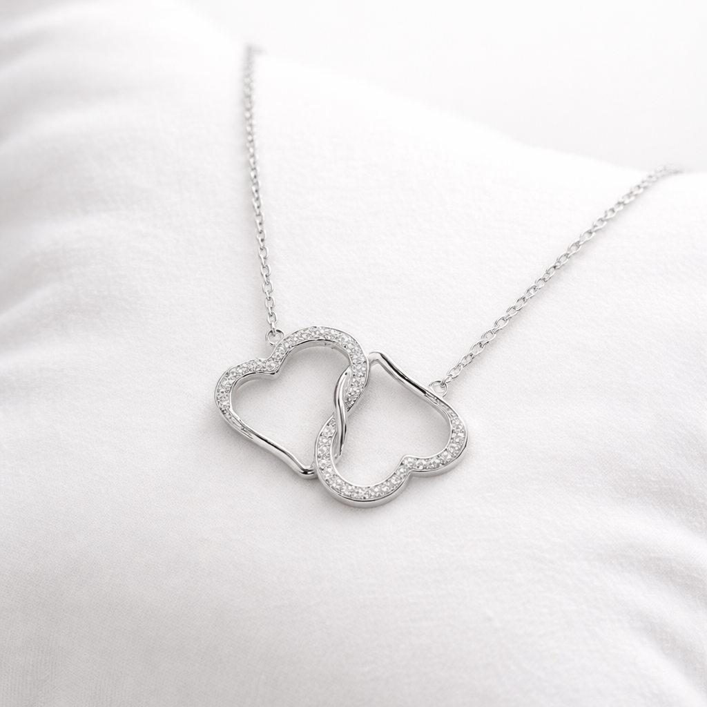 Silver necklace with a unique pendant on a white cushion