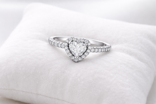 Heart-shaped diamond ring on a white cushion