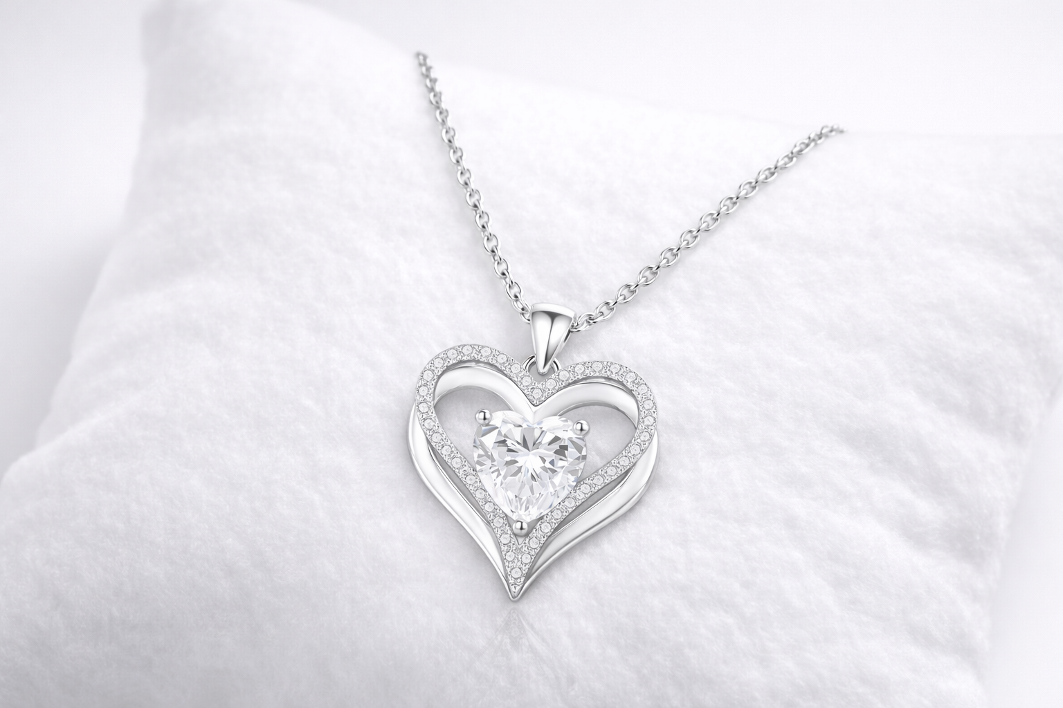 Silver heart-shaped pendant with a diamond on a white background