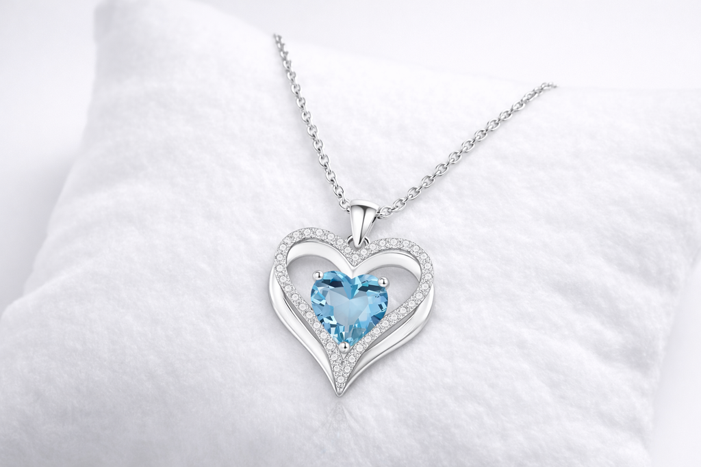 Heart-shaped pendant with a blue gemstone on a white background