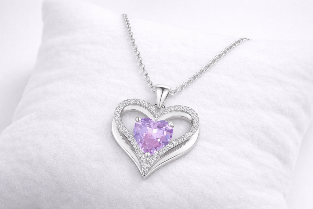 Heart-shaped silver pendant with a purple gemstone on a white background
