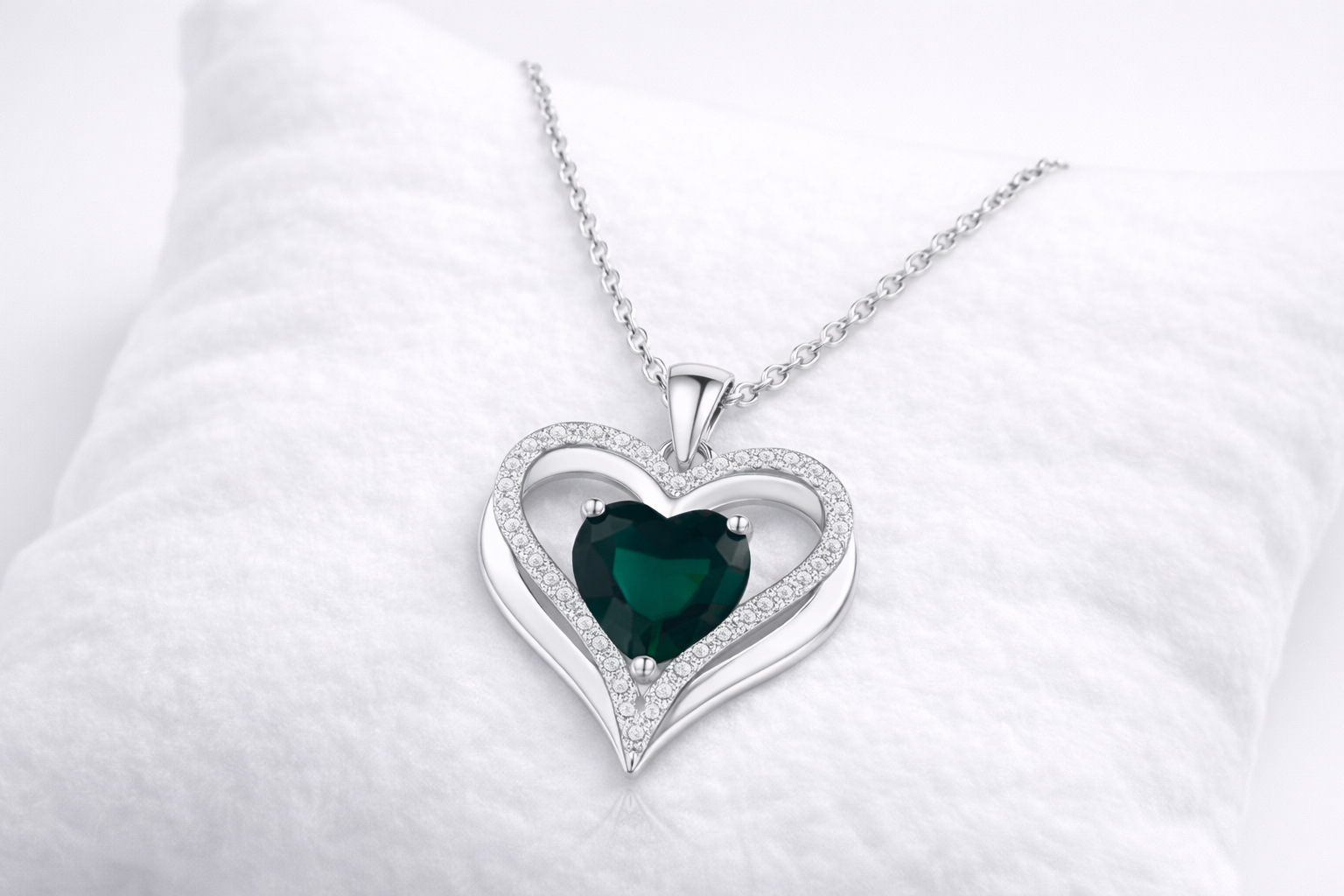 Heart-shaped pendant with a green gemstone on a white background