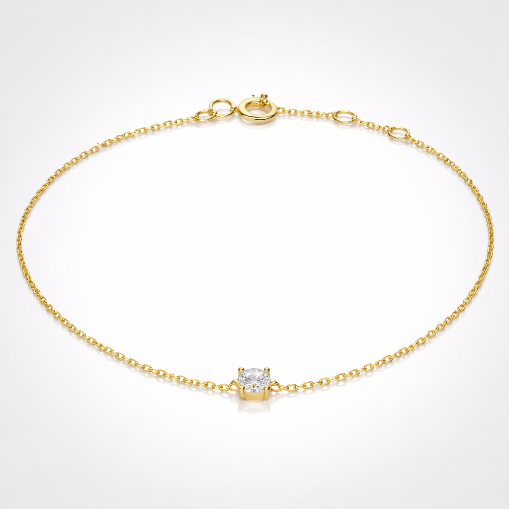 Gold bracelet with a diamond charm on a white background