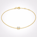 Gold bracelet with a diamond charm on a white background