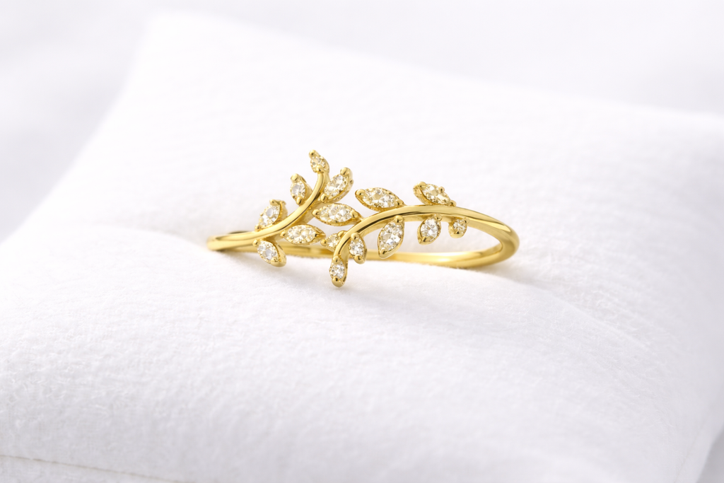 Gold leaf-shaped earring on a white cushion