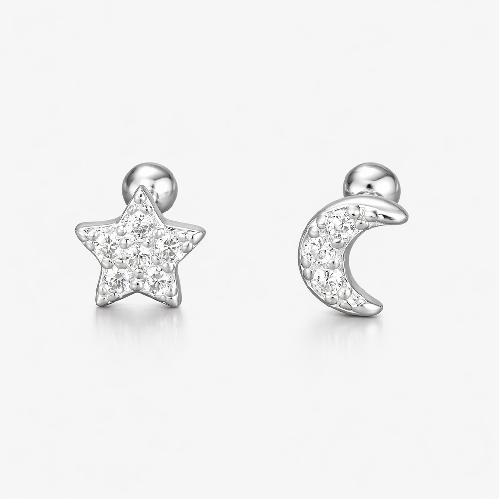 Star and moon-shaped earrings with clear gemstones on a white background