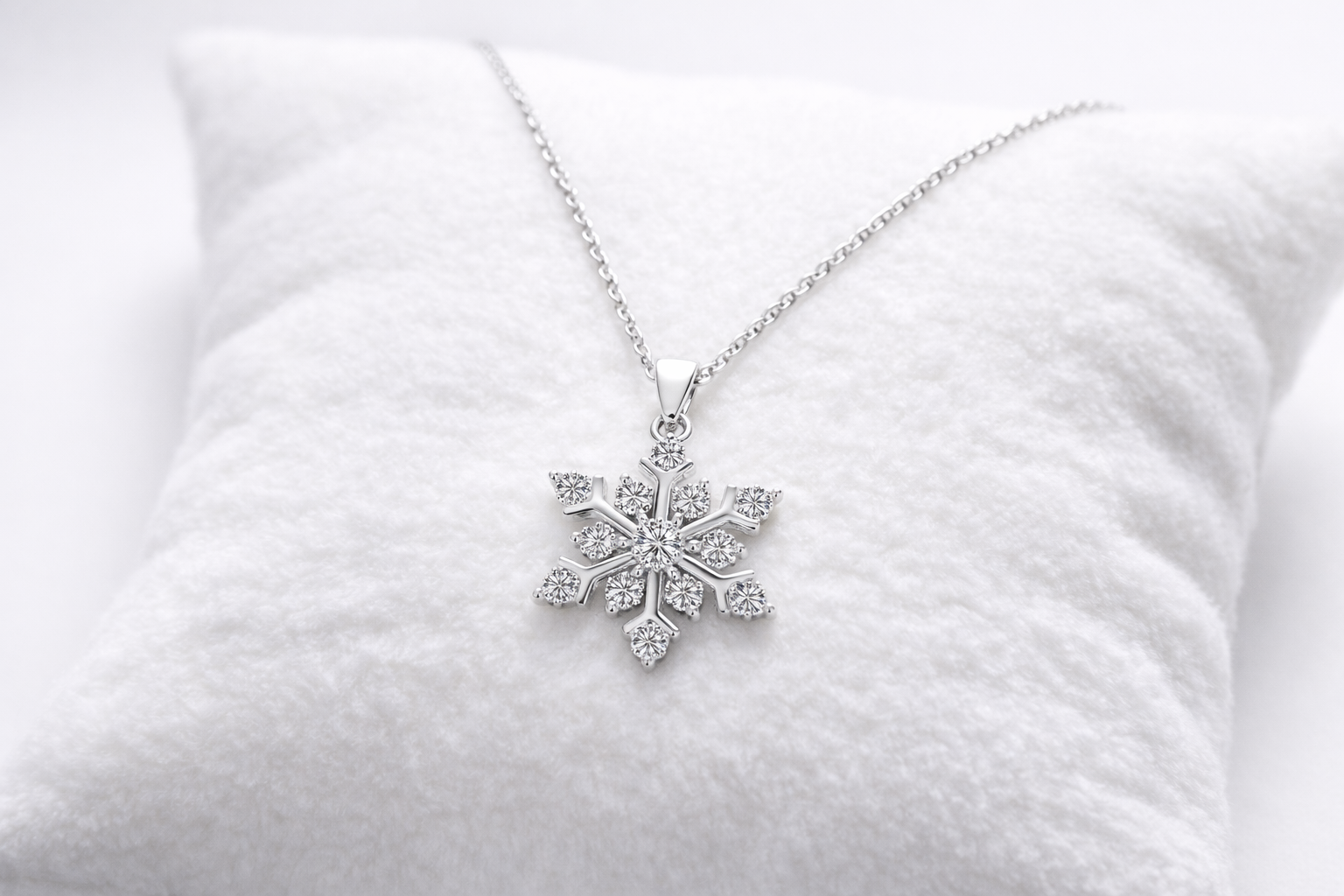 Snowflake-shaped diamond necklace on a white cushion