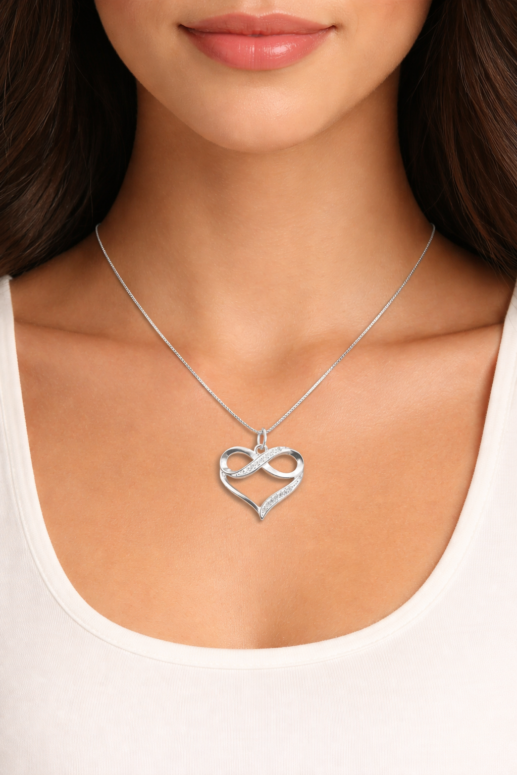 Silver heart-shaped necklace worn by a person