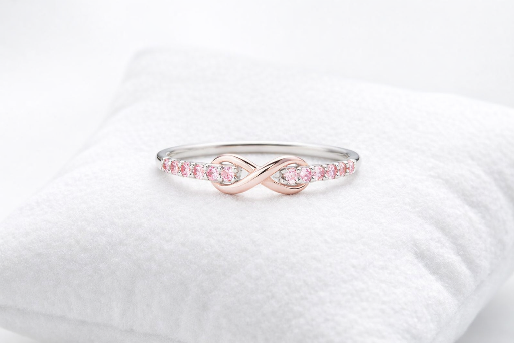 Rose gold ring with pink gemstones on a white background