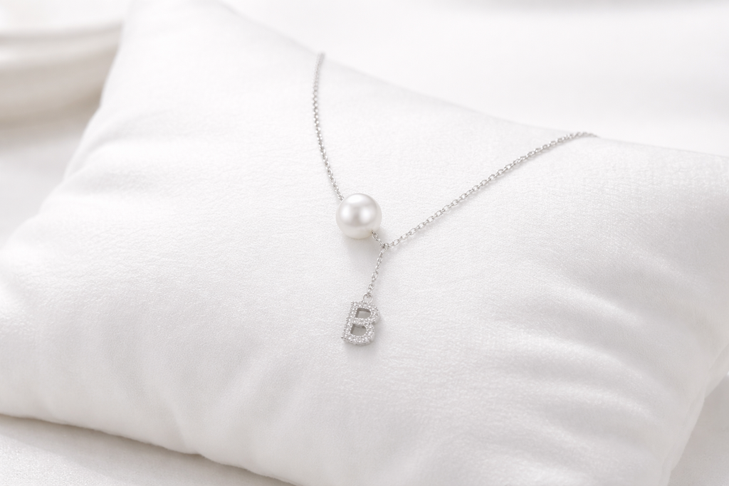 Pearl necklace with a silver clasp on a white fabric background