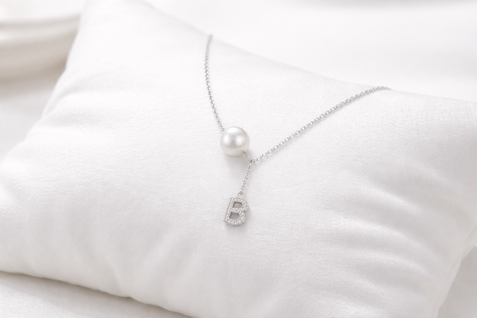 Pearl necklace with a silver clasp on a white fabric background