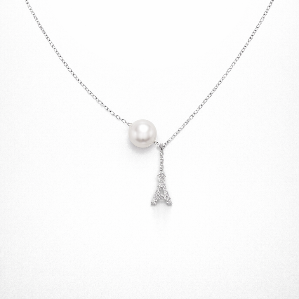 Necklace with a pearl pendant and Eiffel Tower charm on a white background