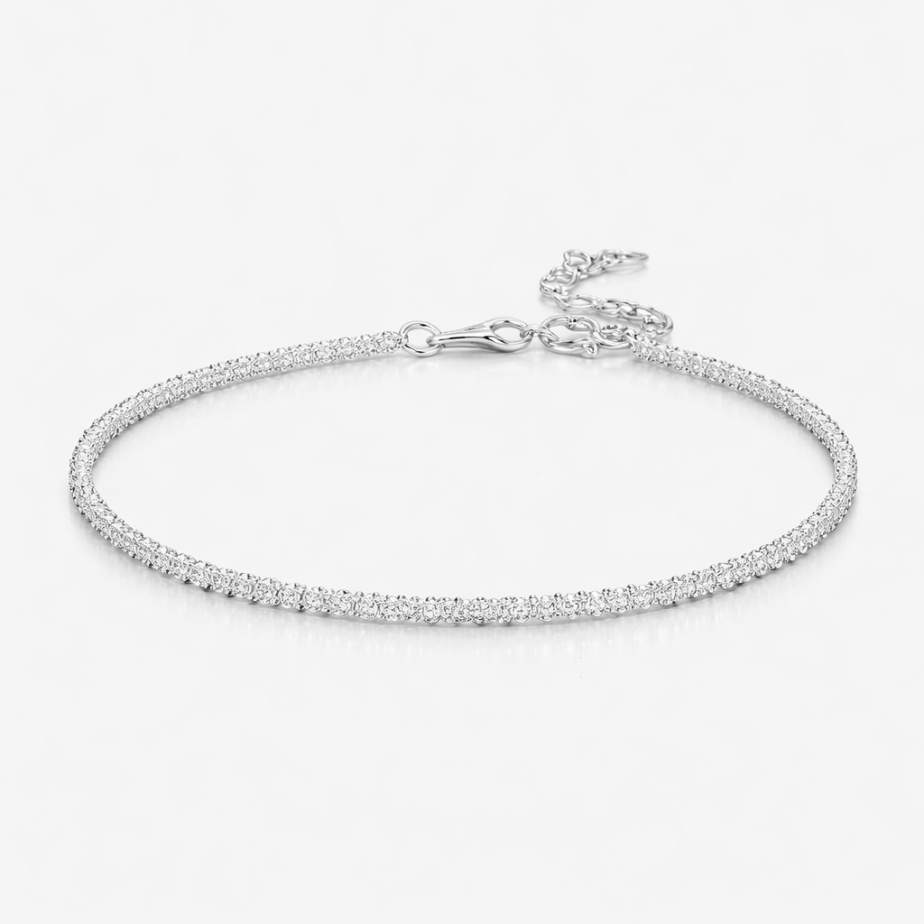 Silver bracelet with small diamonds on a light gray background