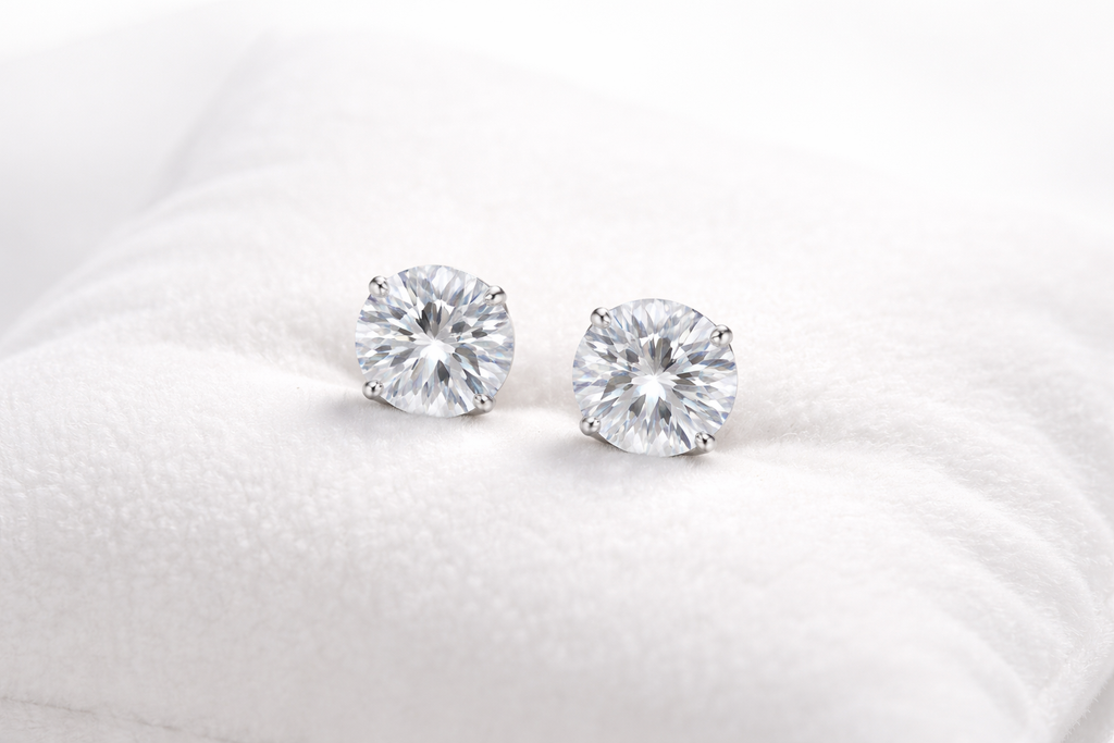 Pair of diamond stud earrings on a white cushion