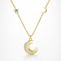 Gold necklace with moon and star pendants on a white background