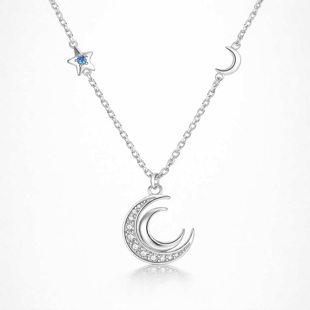Silver necklace with moon and star pendants on a white background
