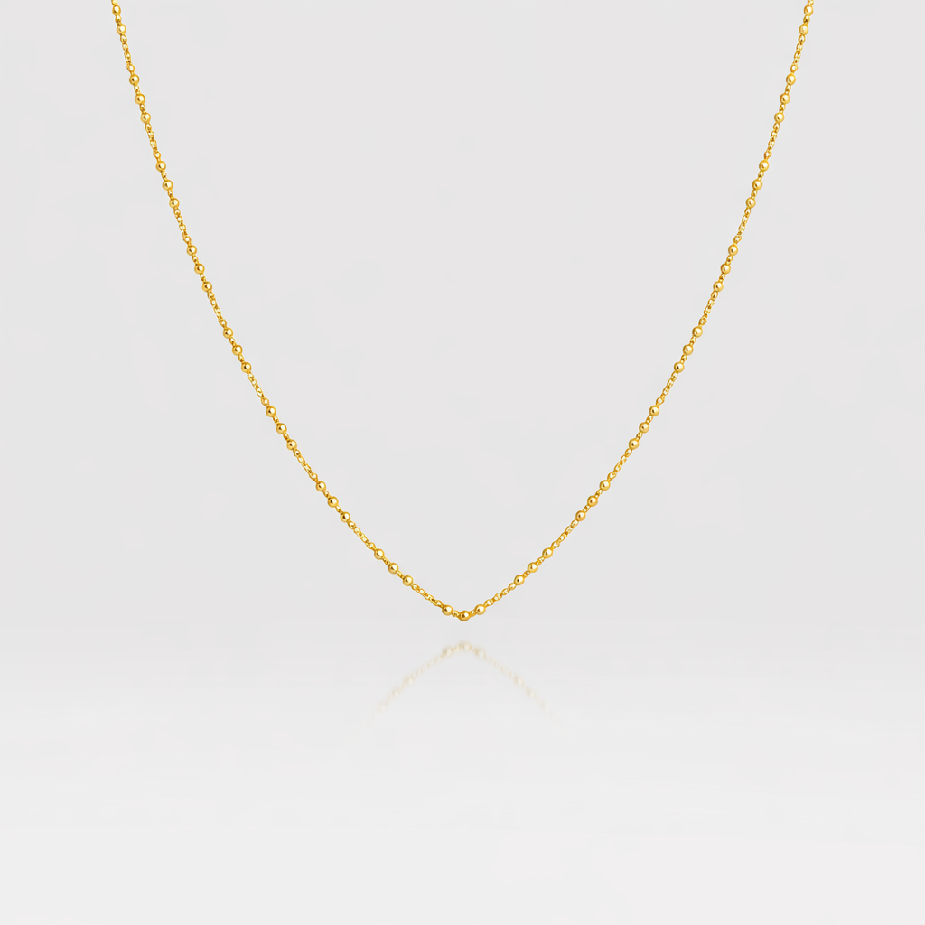 Gold chain necklace on a light gray background