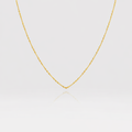 Gold chain necklace on a light gray background