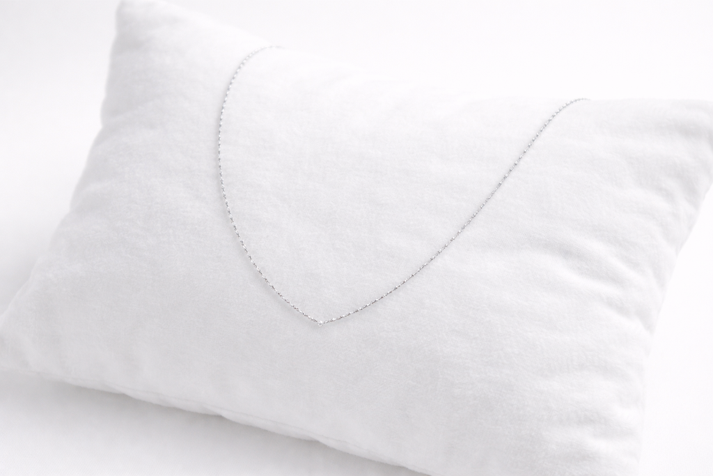 Close-up of a white pillow with a heart-shaped cutout on a light gray background