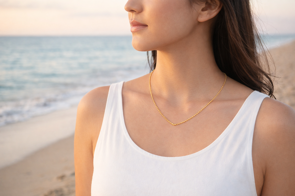 Woman wearing a gold necklace on a beach
