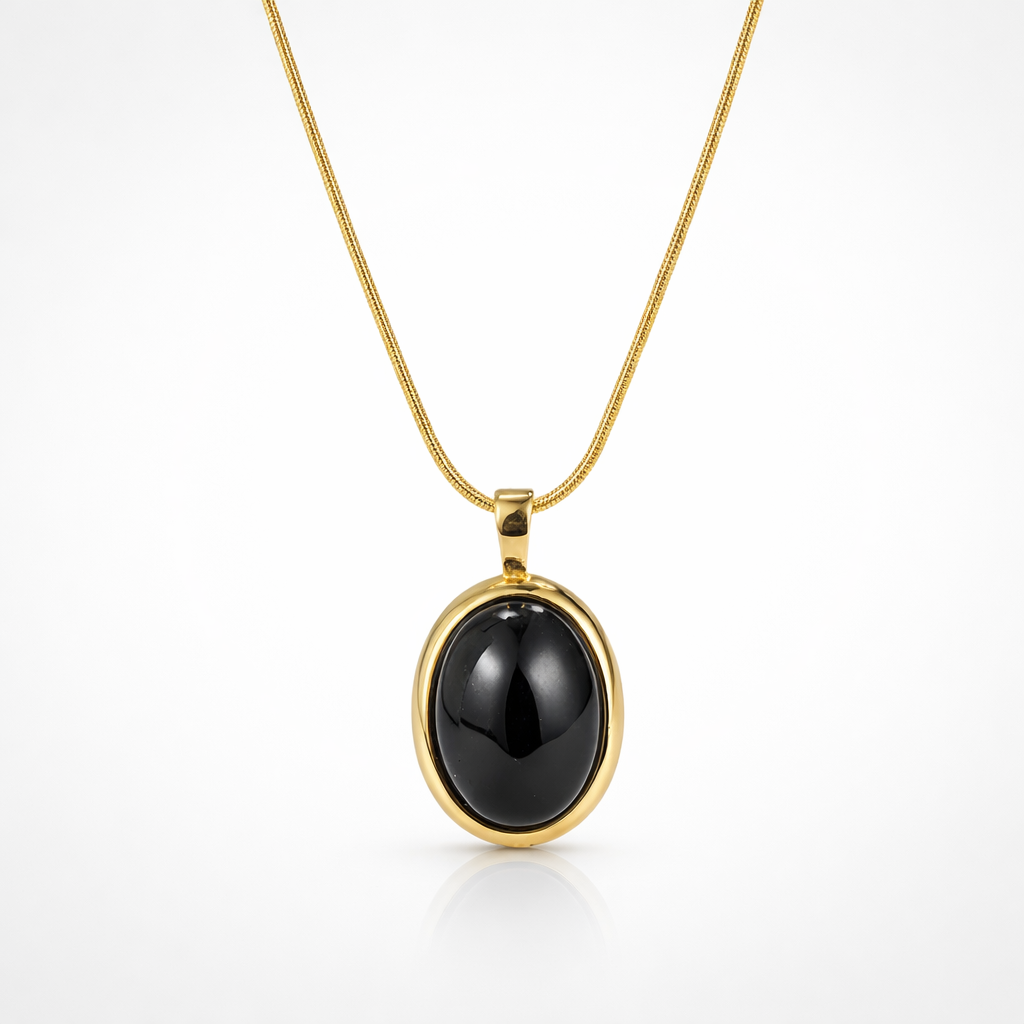 Gold necklace with a black pendant on a white background
