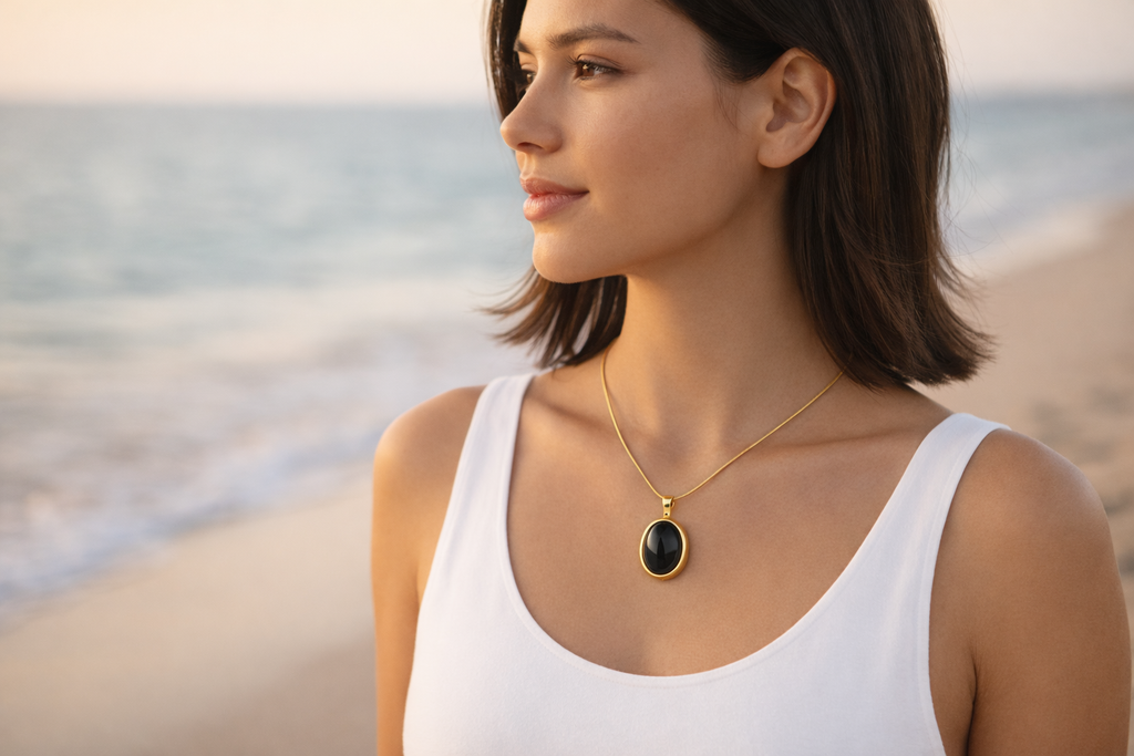 Woman wearing a necklace with a black pendant on a beach