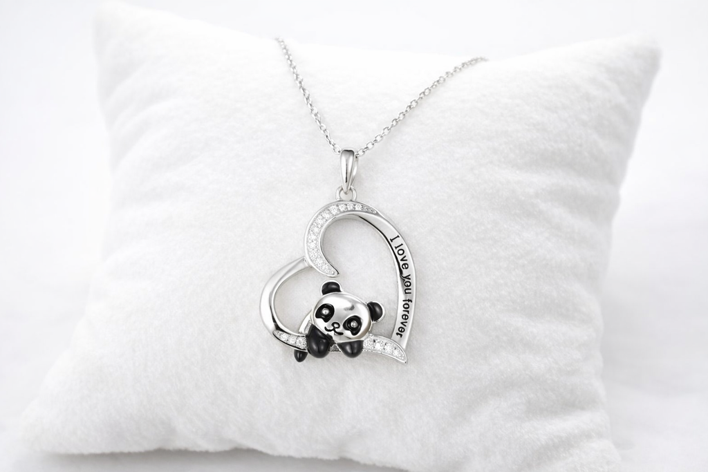Heart-shaped necklace with panda charm on a white pillow