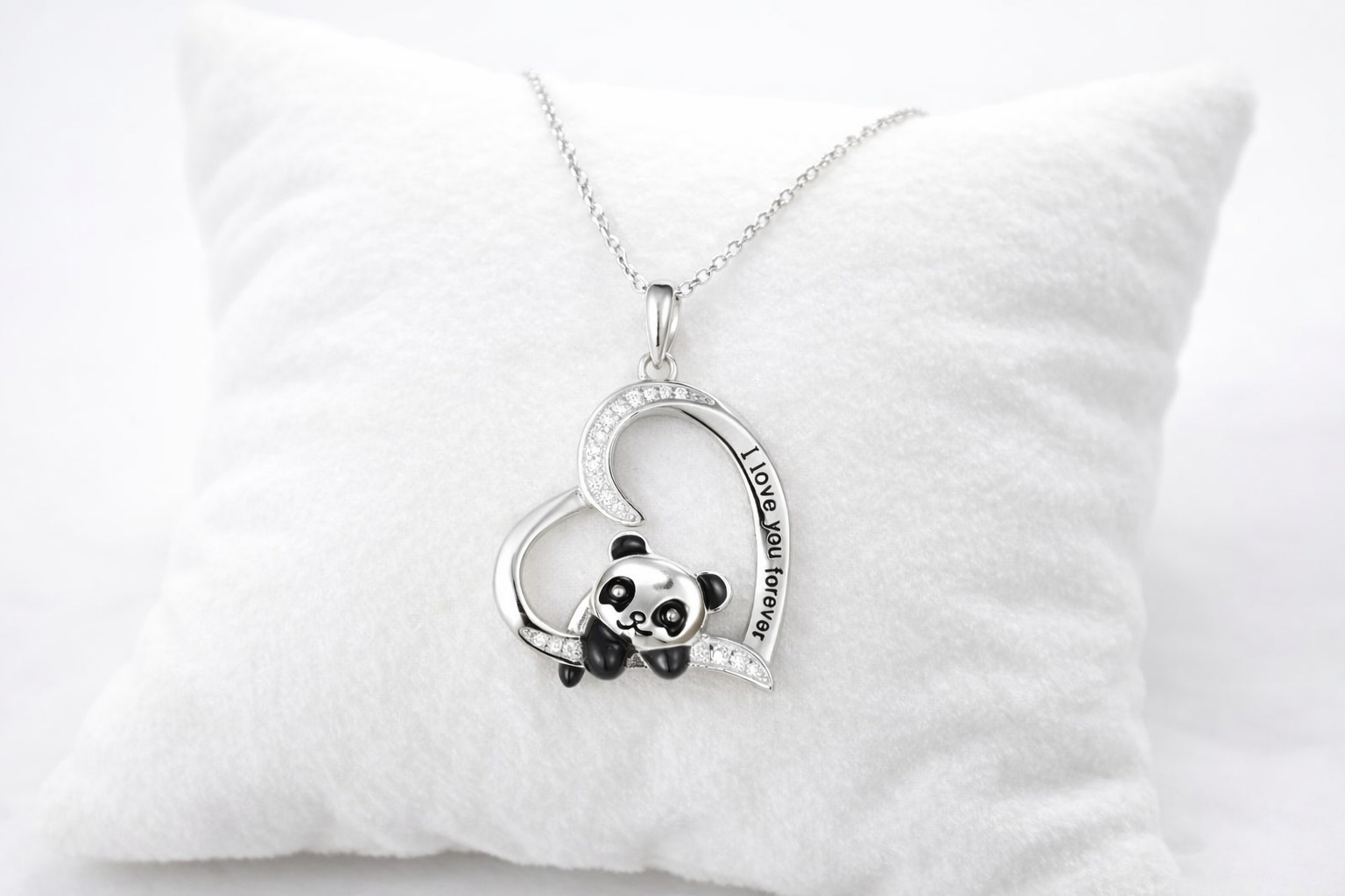 Heart-shaped necklace with panda charm on a white pillow
