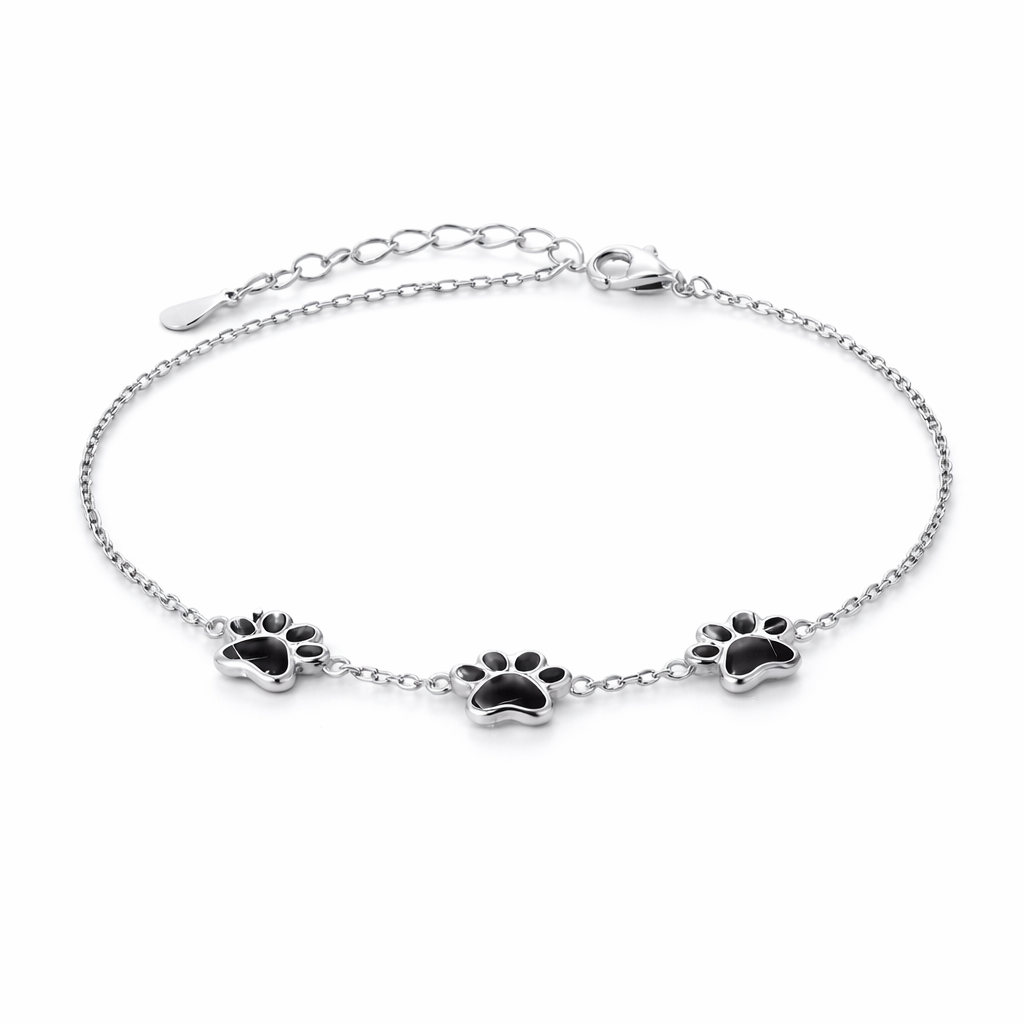 Silver bracelet with black paw print charms on a white background
