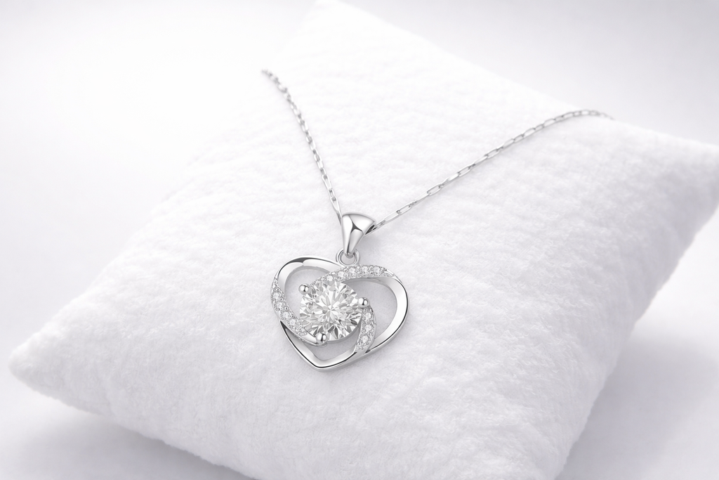 Silver heart-shaped pendant on a white cushion