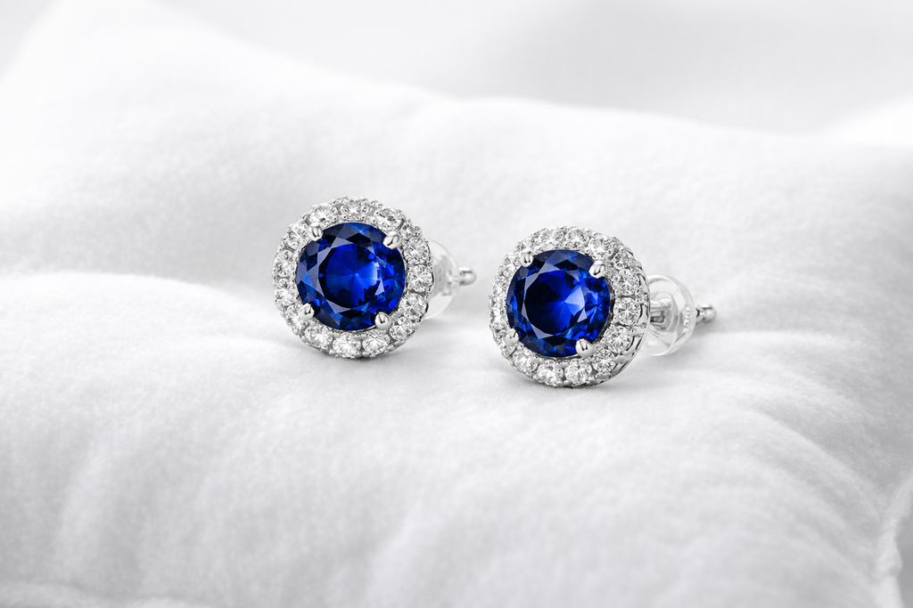 Pair of silver earrings with blue gemstones on a white background