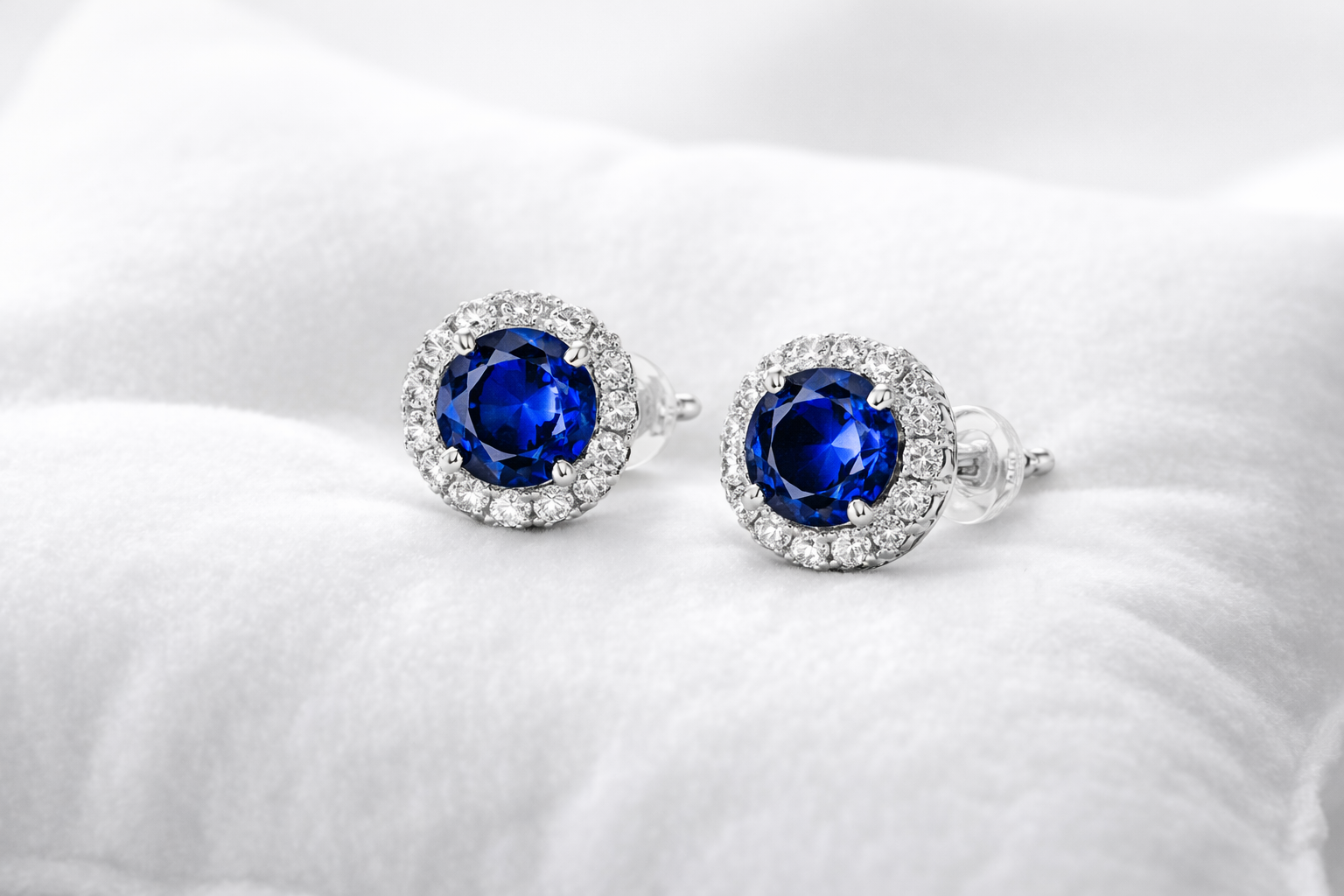 Pair of silver earrings with blue gemstones on a white background
