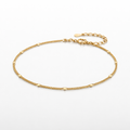 Gold anklet on a white background