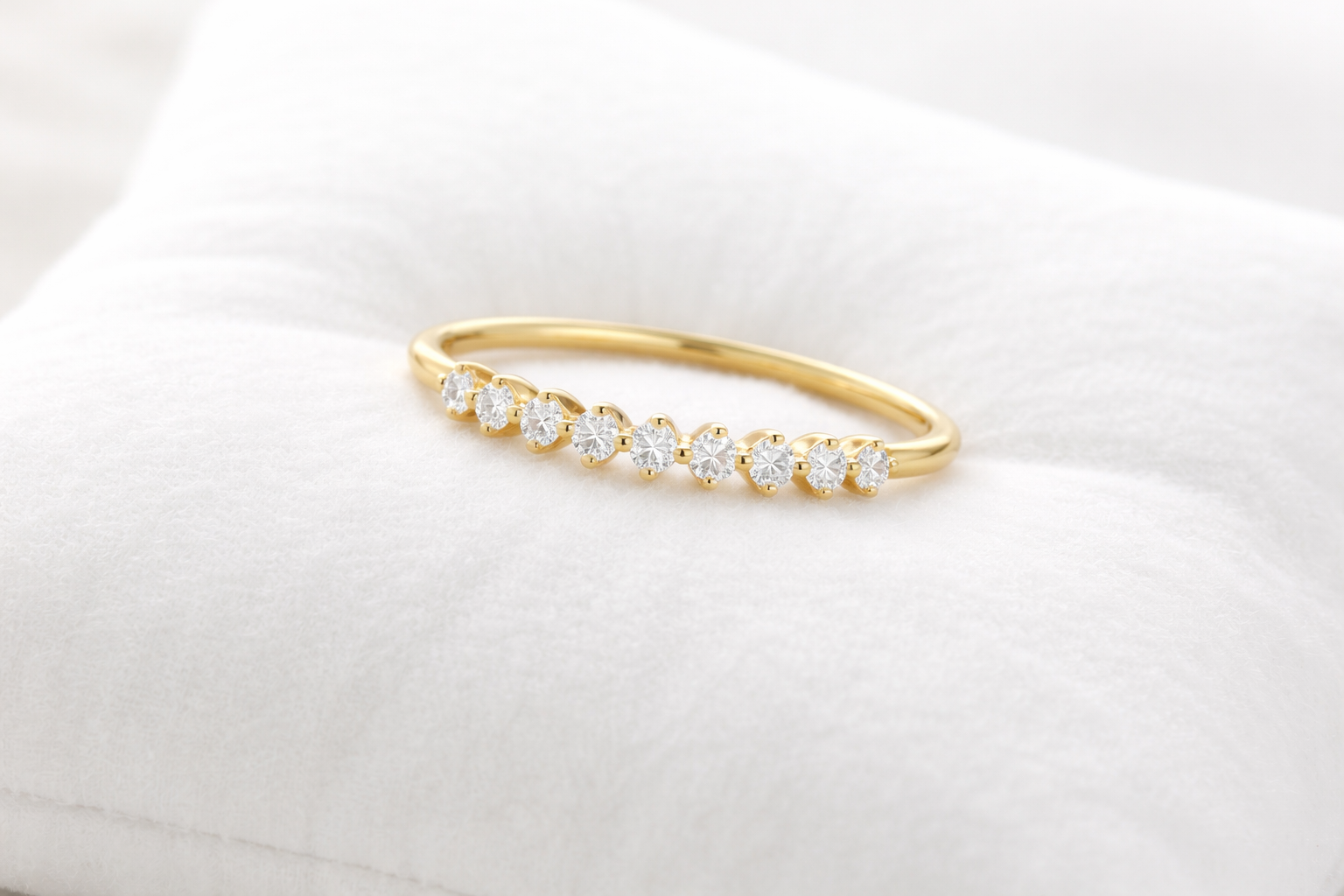 Gold bracelet with clear stones on a white cushion