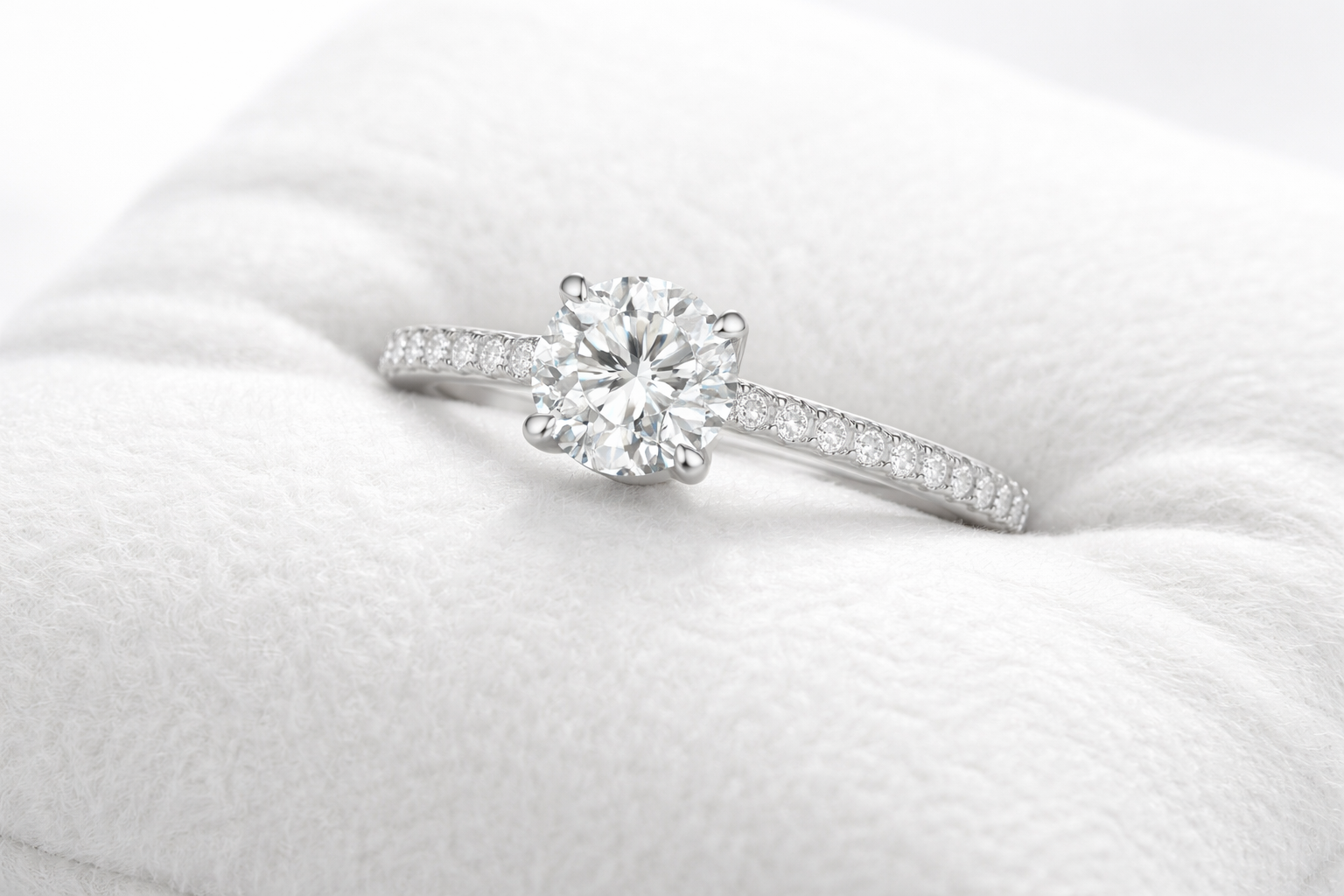 silver diamond ring on white pillow