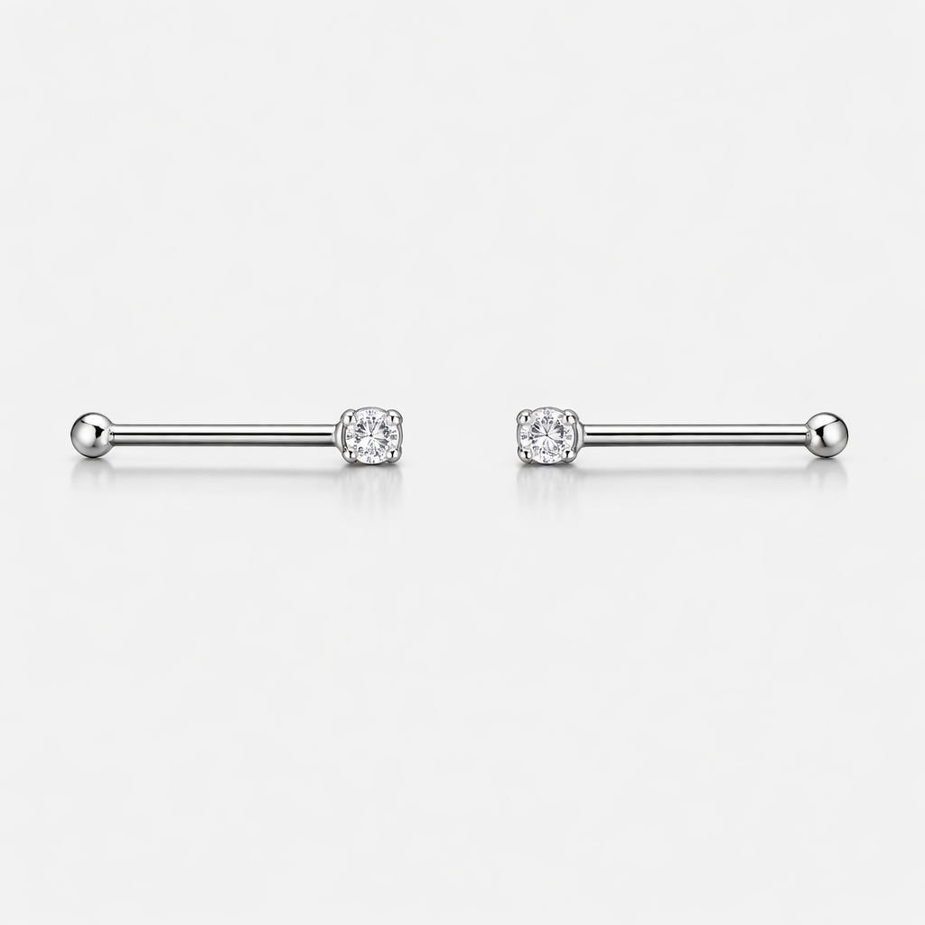 Pair of silver barbell earrings with clear gemstones on a white background
