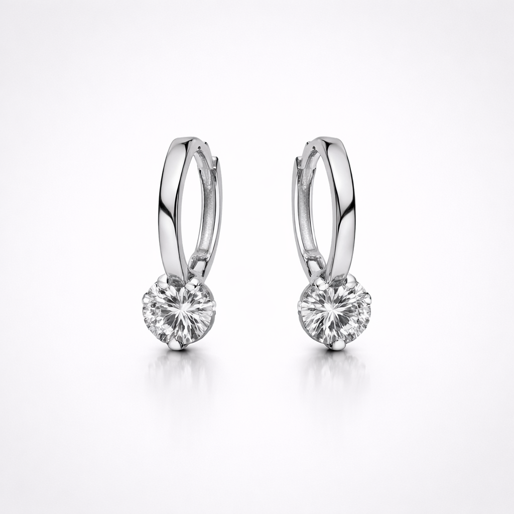 Pair of silver hoop earrings with clear gemstones on a white background