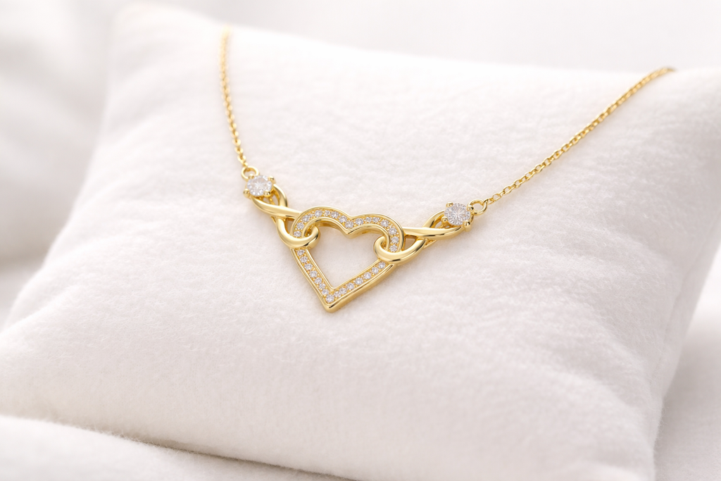 Gold necklace with a heart design on a white cushion