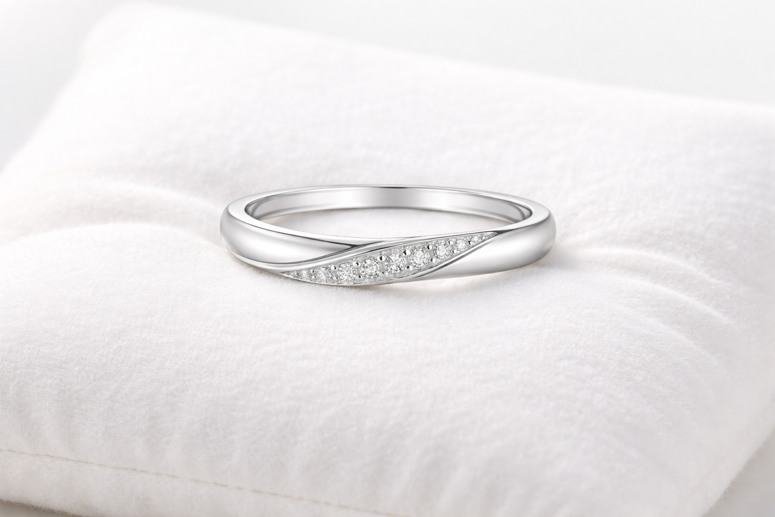Silver ring with small diamonds on a white cushion