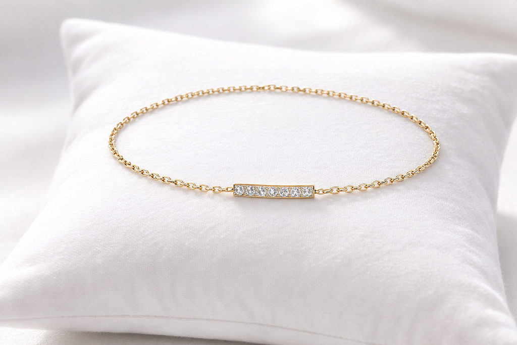 Gold bracelet with small diamonds on a white pillow