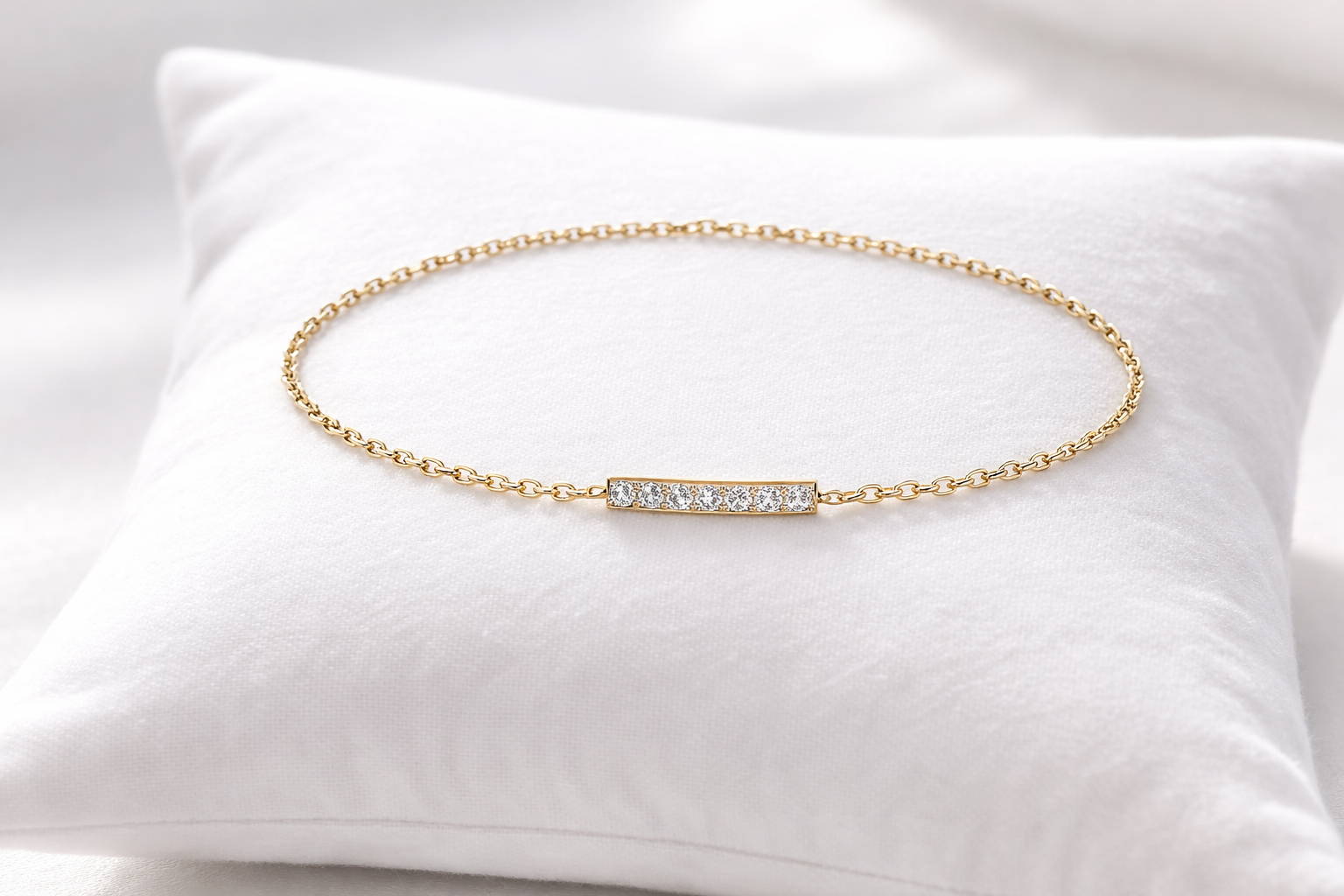 Gold bracelet with small diamonds on a white pillow