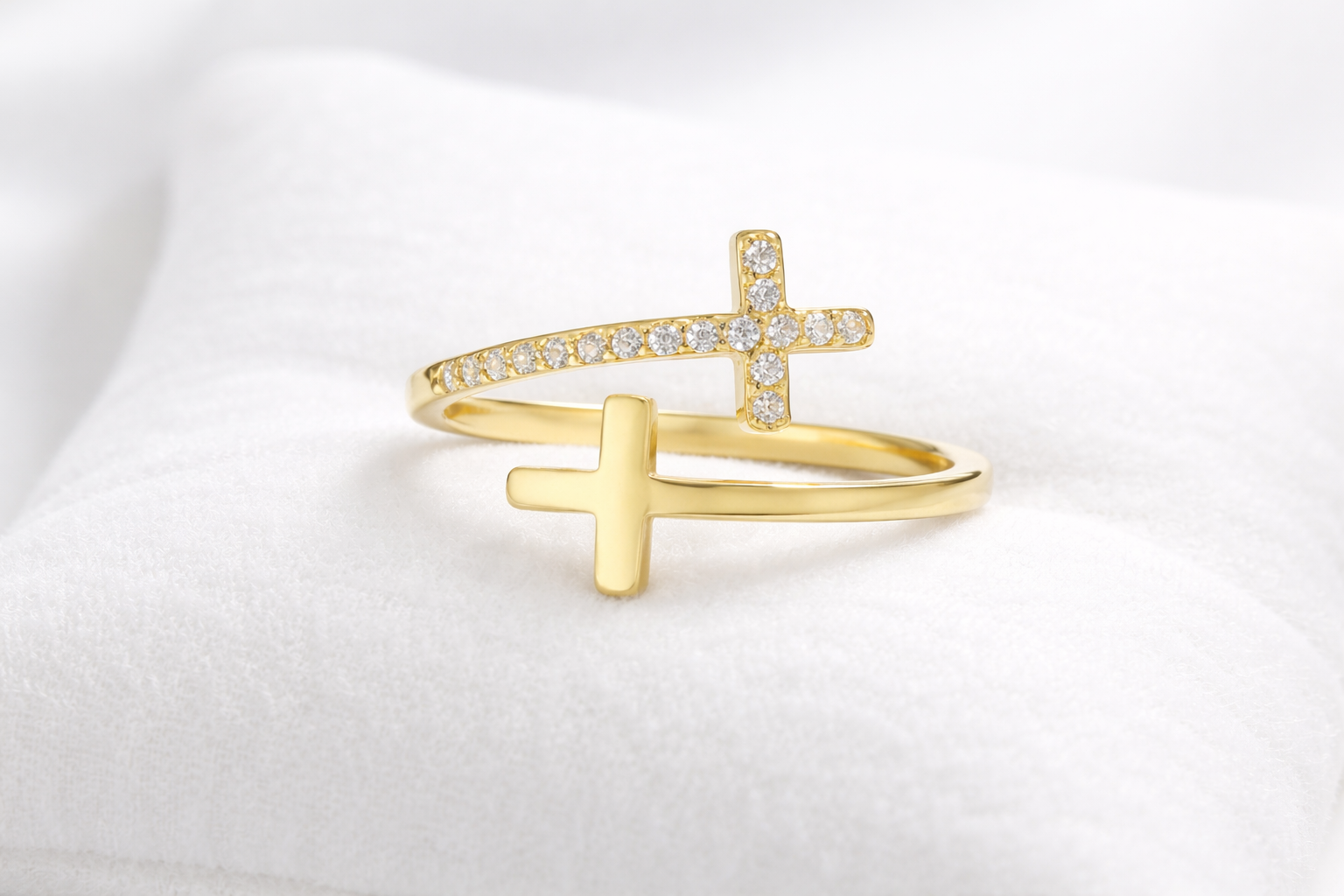 Gold ring with a cross design on a white background