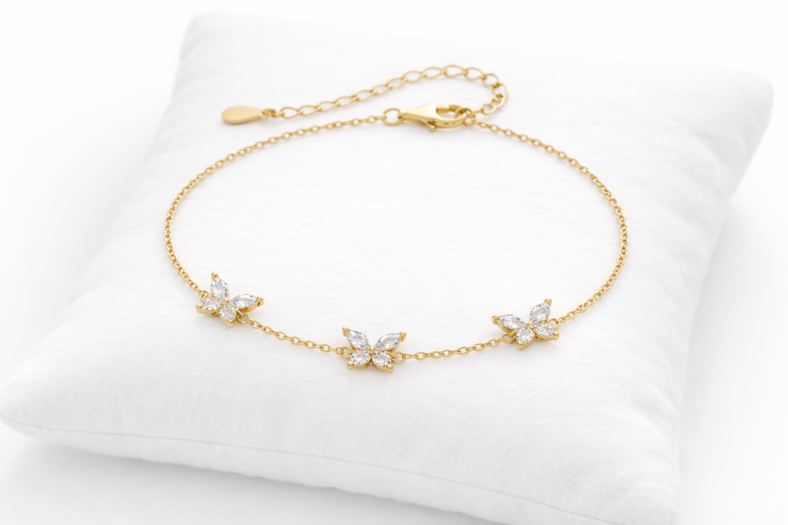 Gold bracelet with diamond-like stones on a white cushion