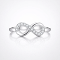 Silver infinity ring with small diamonds on a light gray background