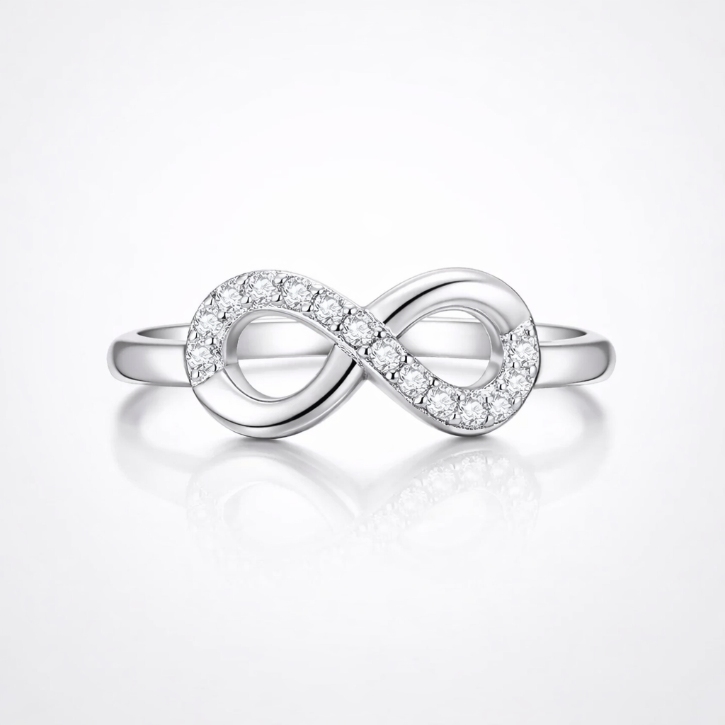 Silver infinity ring with small diamonds on a light gray background
