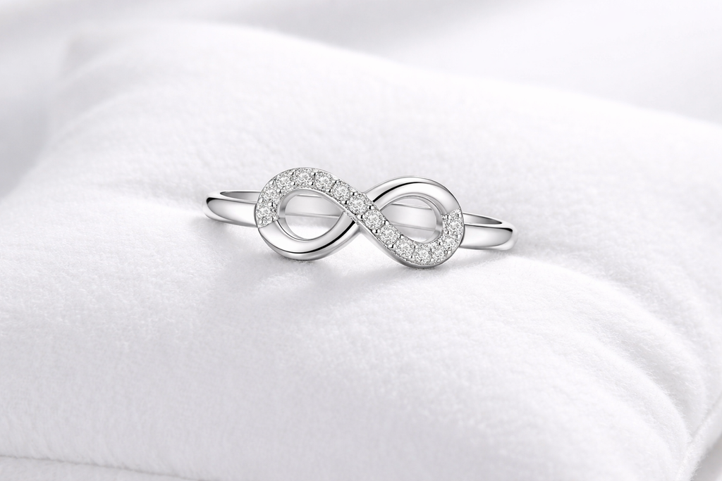 Silver infinity ring on a white satin background