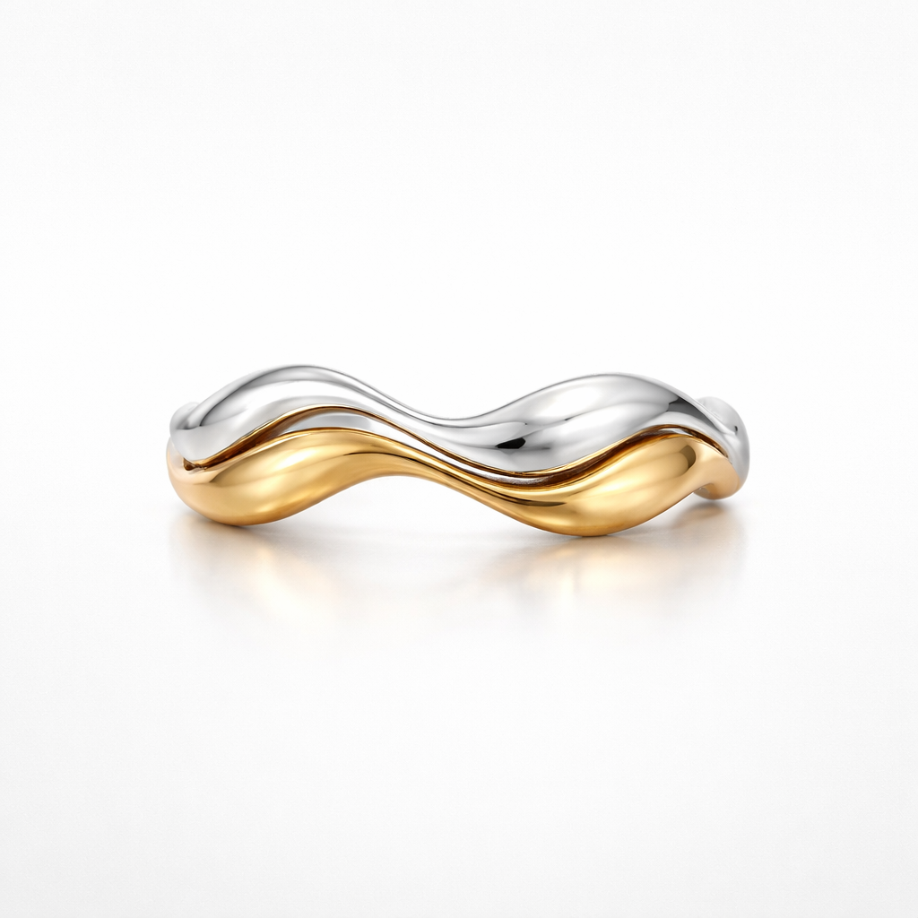 Two-toned ring with gold and silver wave design on a white background